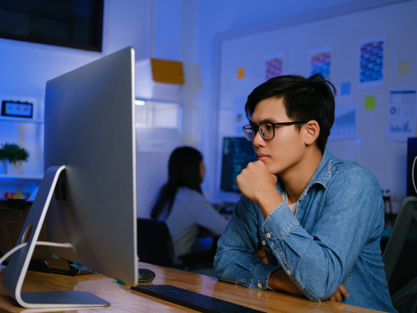 A global pharma leader - an Asian man working in an office in front of a monitor